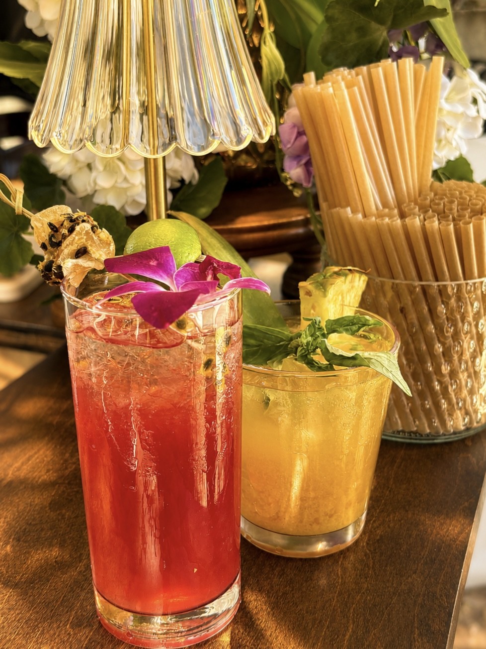 Pink and yellow cocktails beneath a glass lamp