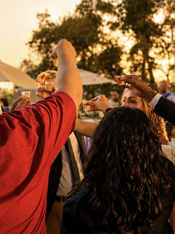 Guests raising their glasses at sunset