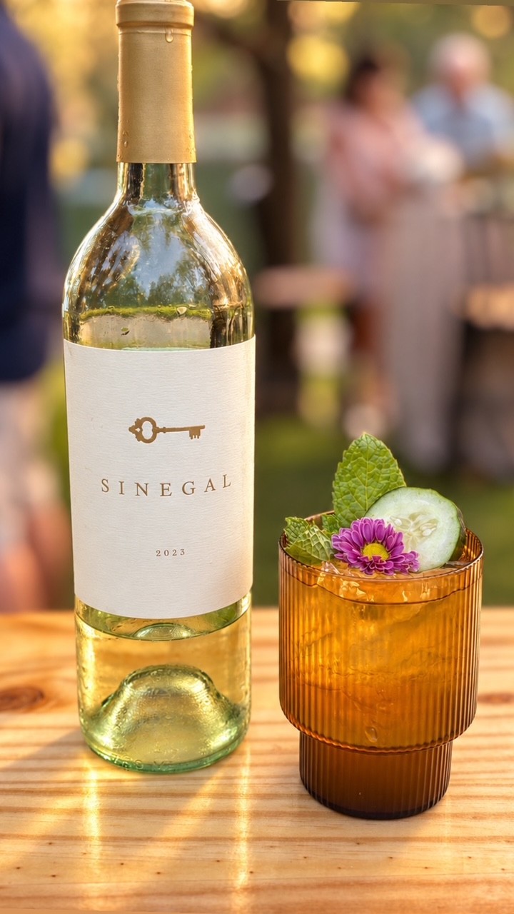 Wine bottle and a garnished beverage on the bar